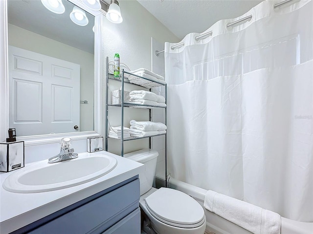 bathroom featuring shower / tub combo with curtain, vanity, toilet, and a textured ceiling