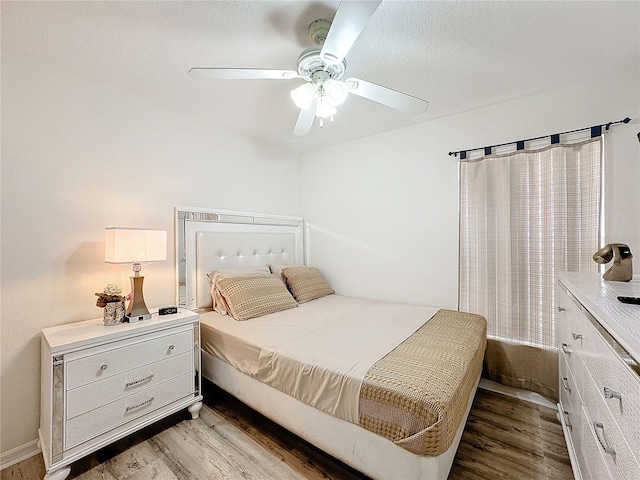 bedroom with a ceiling fan and light wood-style flooring