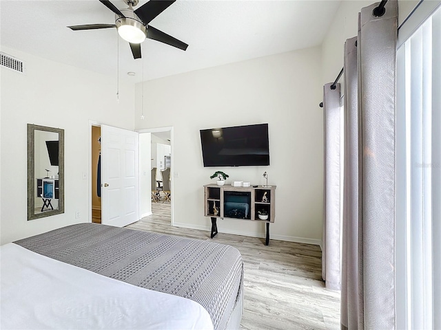 bedroom with light wood-type flooring, baseboards, visible vents, and ceiling fan