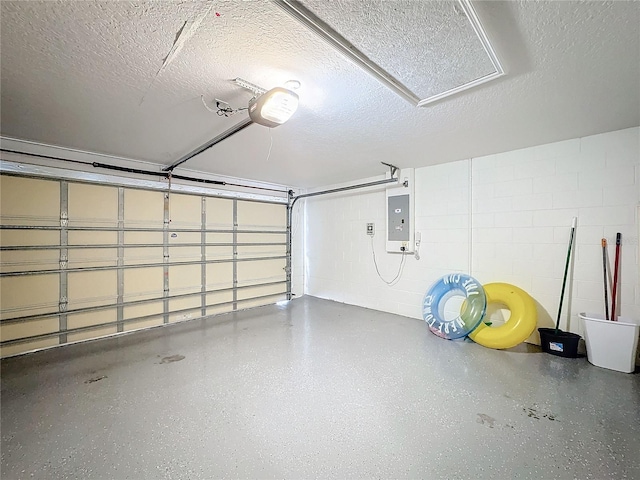 garage featuring a garage door opener, concrete block wall, and electric panel