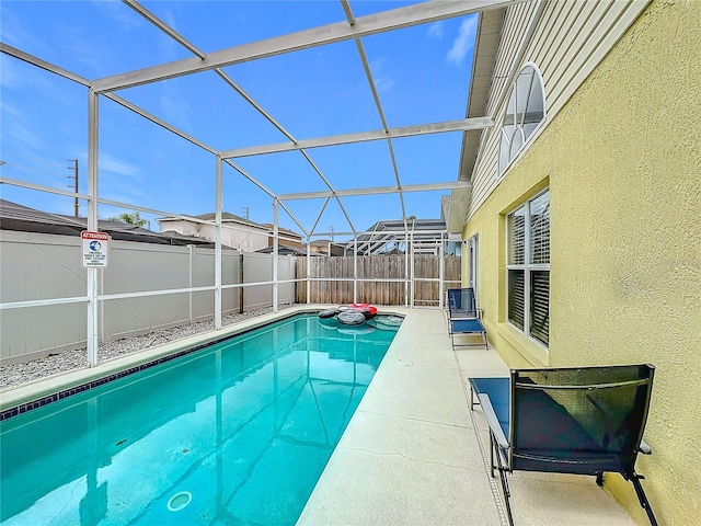 view of swimming pool featuring a patio area, a fenced backyard, glass enclosure, and a fenced in pool