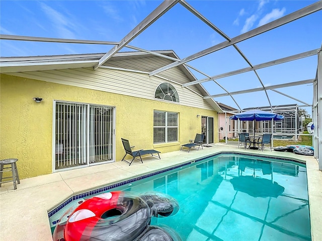 pool with glass enclosure and a patio area