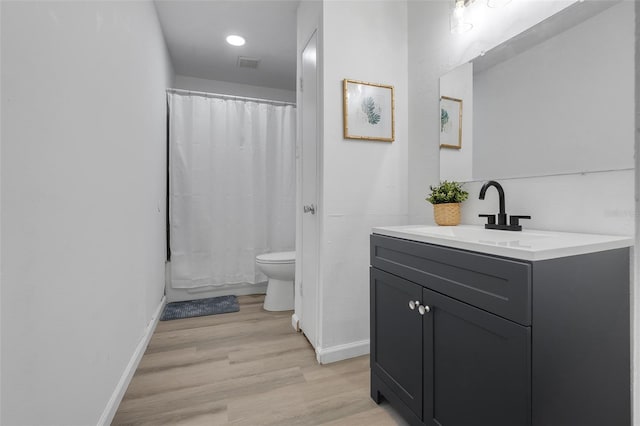 full bath with toilet, wood finished floors, visible vents, vanity, and baseboards