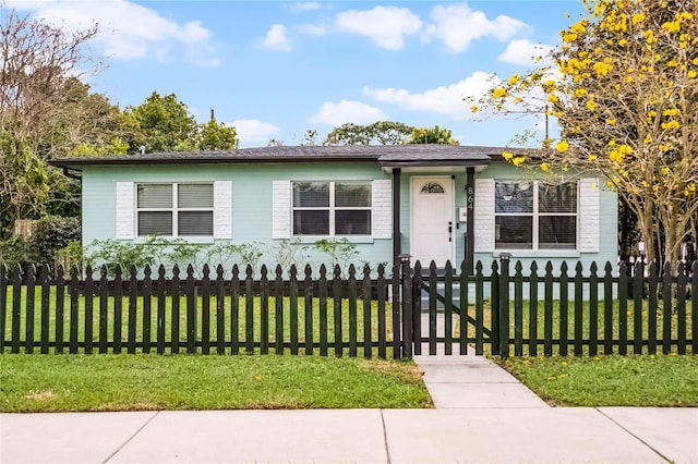 view of front of home featuring a fenced front yard and a front lawn