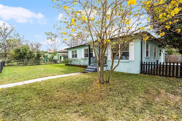 view of front of house with brick siding, fence, and a front yard