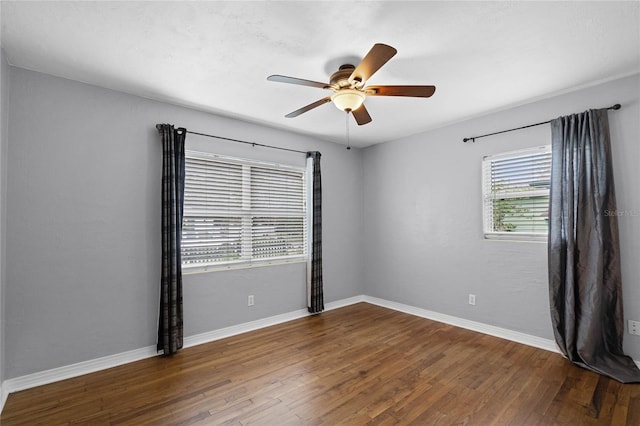 empty room with dark wood-style floors, ceiling fan, and baseboards