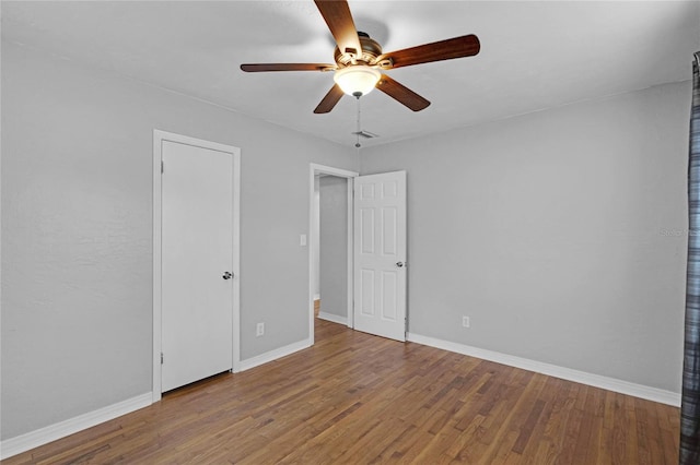 unfurnished bedroom featuring a ceiling fan, baseboards, and wood finished floors