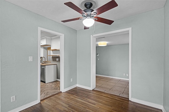 spare room with a ceiling fan, baseboards, and wood finished floors