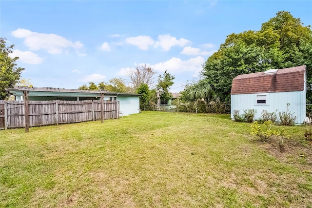 view of yard featuring an outbuilding, fence, and a shed