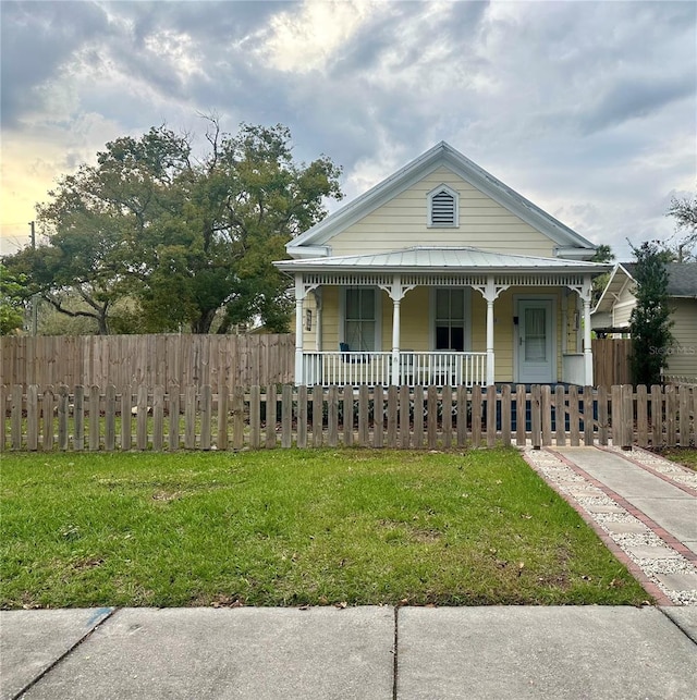 view of front of home featuring a porch, a front yard, and a fenced front yard