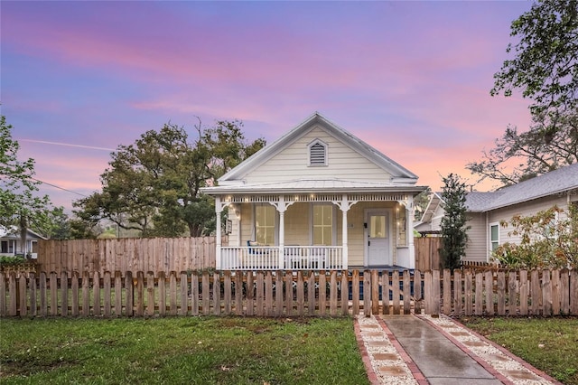 view of front facade with covered porch and a fenced front yard