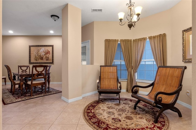 living area with baseboards, light tile patterned flooring, visible vents, and an inviting chandelier