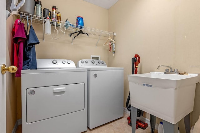 1562 Travertine Ter, Sanford, FL 32771 - laundry area featuring laundry area, light tile patterned flooring, a sink, and washer and clothes dryer