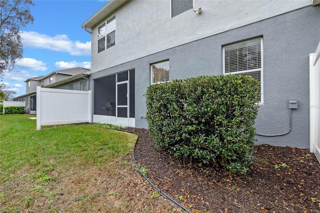 1562 Travertine Ter, Sanford, FL 32771 - back of property with stucco siding, fence, a sunroom, and a yard