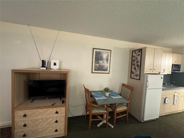 dining space with dark colored carpet and a textured ceiling