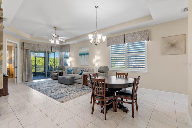 dining area featuring ceiling fan with notable chandelier, a raised ceiling, and visible vents