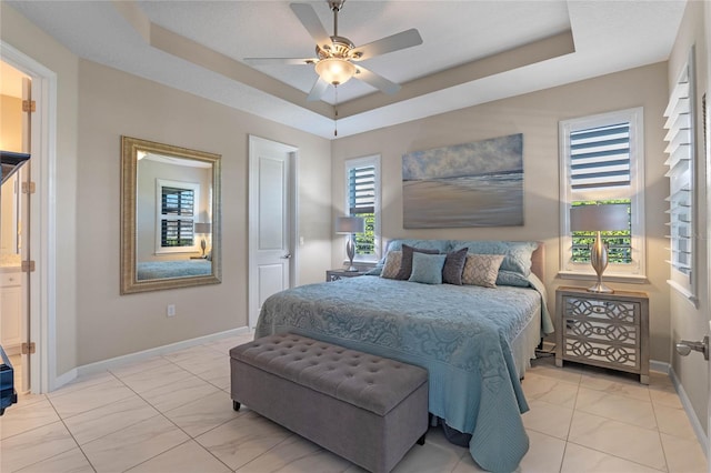 bedroom with ceiling fan, a raised ceiling, and baseboards