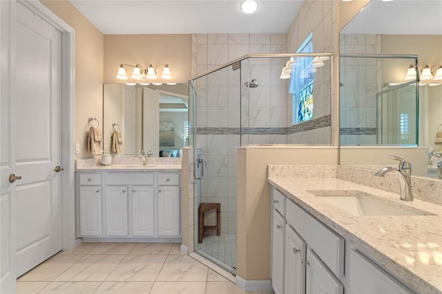 bathroom featuring marble finish floor, two vanities, a sink, and a shower stall