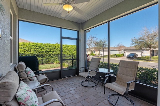 sunroom / solarium featuring a ceiling fan