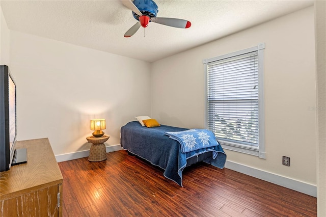 bedroom with ceiling fan, a textured ceiling, baseboards, and wood finished floors