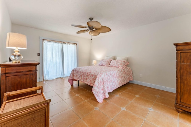 bedroom featuring a ceiling fan, baseboards, and light tile patterned floors