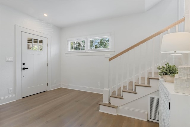 entrance foyer featuring baseboards, visible vents, wood finished floors, stairs, and recessed lighting