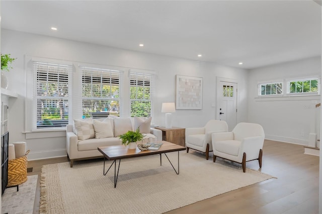 living room with a fireplace, baseboards, wood finished floors, and recessed lighting