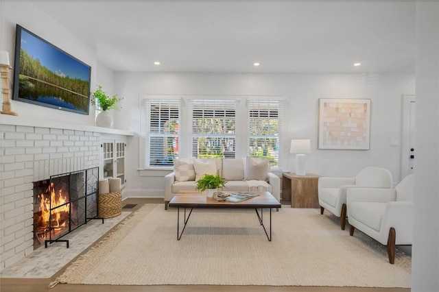 living area featuring baseboards, a fireplace, wood finished floors, and recessed lighting