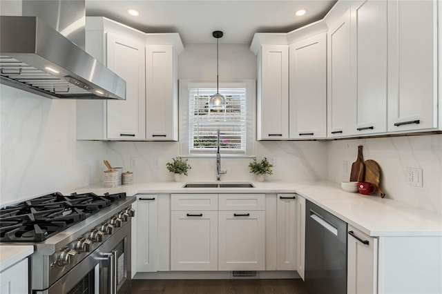 kitchen with white cabinets, wall chimney exhaust hood, stainless steel appliances, and a sink