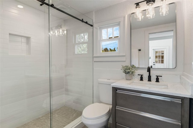 bathroom with a stall shower, vanity, and toilet