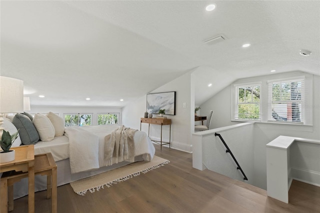 bedroom with lofted ceiling, a textured ceiling, recessed lighting, and wood finished floors