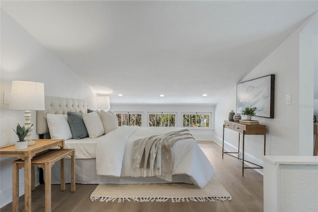 bedroom with baseboards, wood finished floors, and recessed lighting