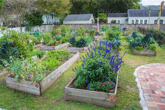 view of yard featuring an outbuilding, a vegetable garden, and fence