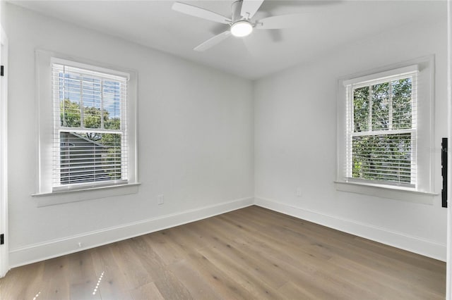 empty room featuring a ceiling fan, baseboards, and wood finished floors