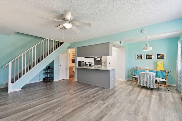 kitchen with ceiling fan, hanging light fixtures, wood finished floors, and baseboards