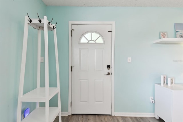 foyer with baseboards and wood finished floors