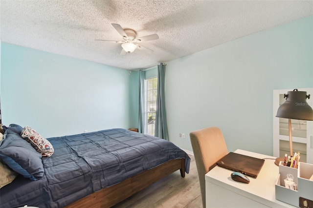 bedroom featuring ceiling fan, a textured ceiling, and wood finished floors