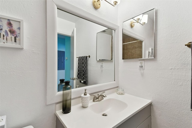 bathroom featuring vanity and a textured wall