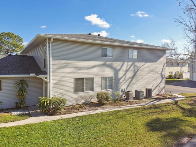 back of house featuring a yard and central air condition unit