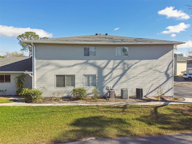 back of house featuring central AC and a yard