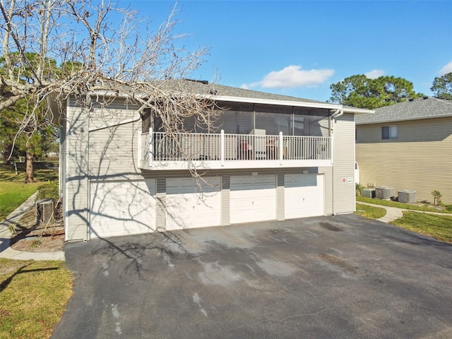 back of house with a garage, driveway, and central AC unit