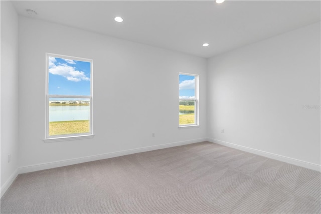 empty room with recessed lighting, baseboards, and light carpet