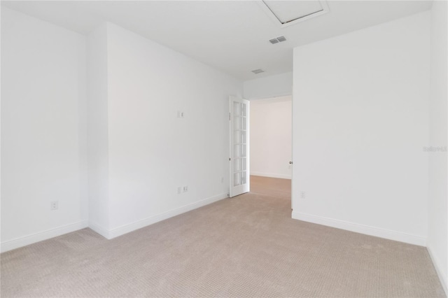 unfurnished room featuring visible vents, light colored carpet, and baseboards