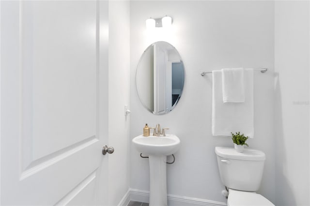 bathroom featuring baseboards and toilet