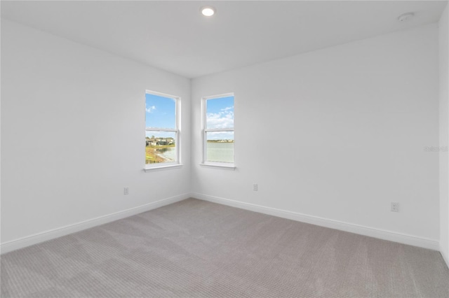 carpeted empty room featuring recessed lighting and baseboards