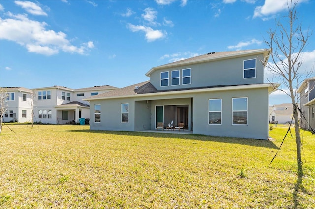 rear view of house featuring stucco siding, a patio, and a lawn