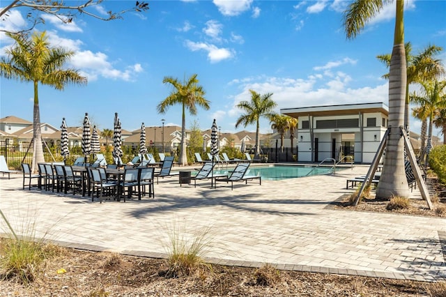 pool with a patio area and fence