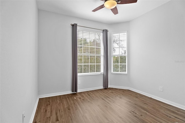 spare room featuring a ceiling fan, baseboards, and light wood finished floors