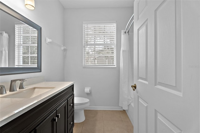 bathroom featuring baseboards, toilet, vanity, and tile patterned floors