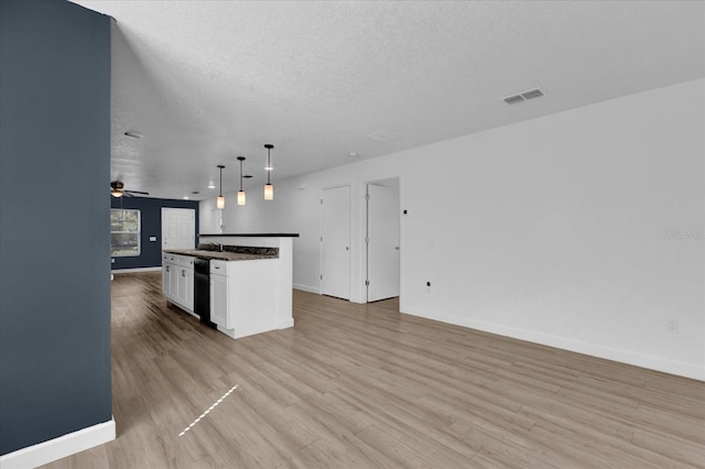 kitchen with visible vents, white cabinetry, open floor plan, dark countertops, and decorative light fixtures